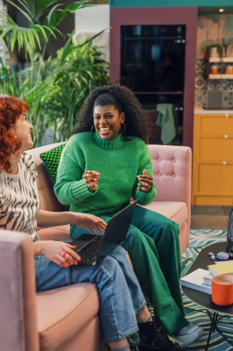 Two ladies sitting on a couch talking about bookkeeping